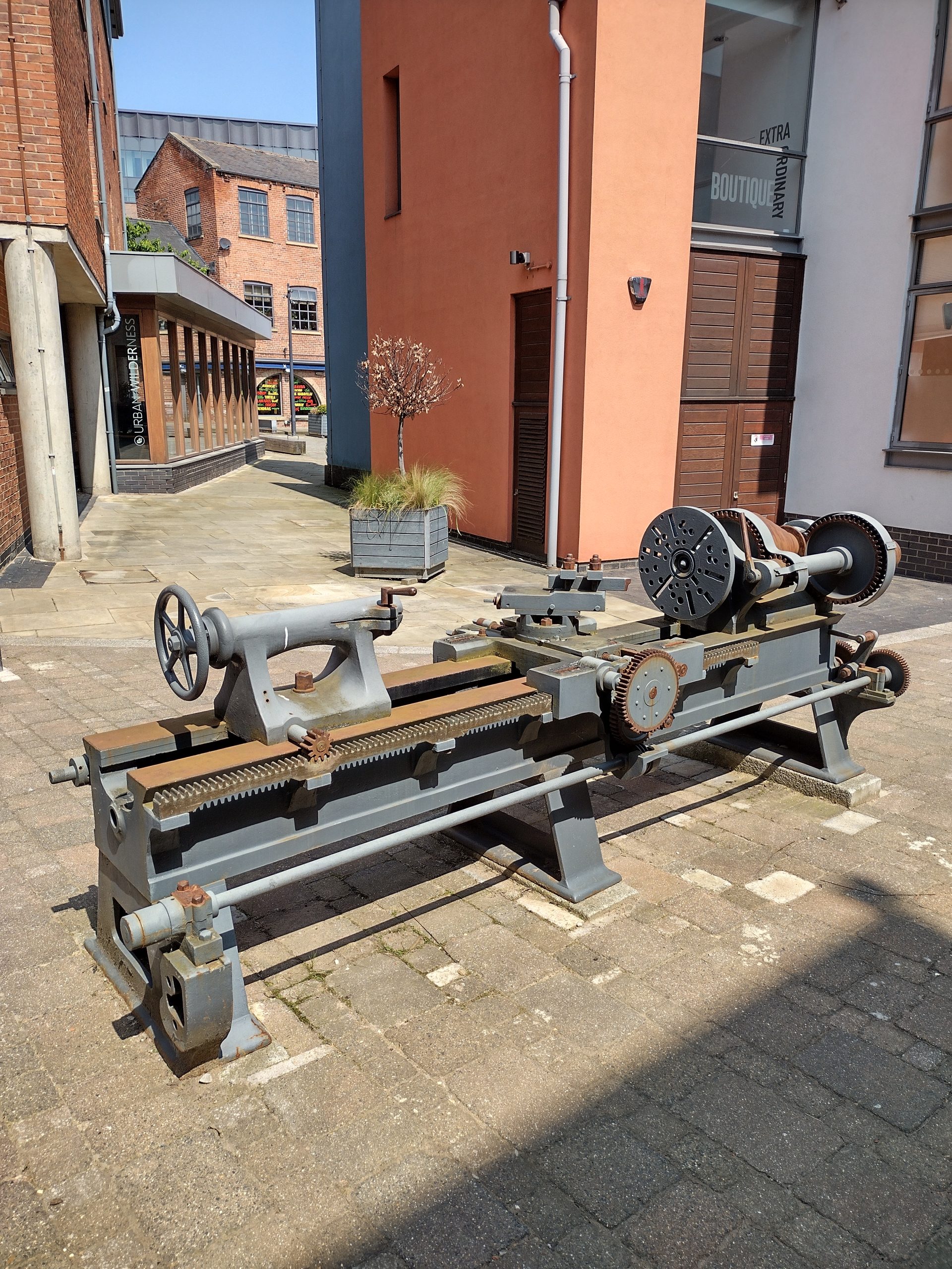 A wood or metal turning lathe on display in a yard near Marshall's Mill