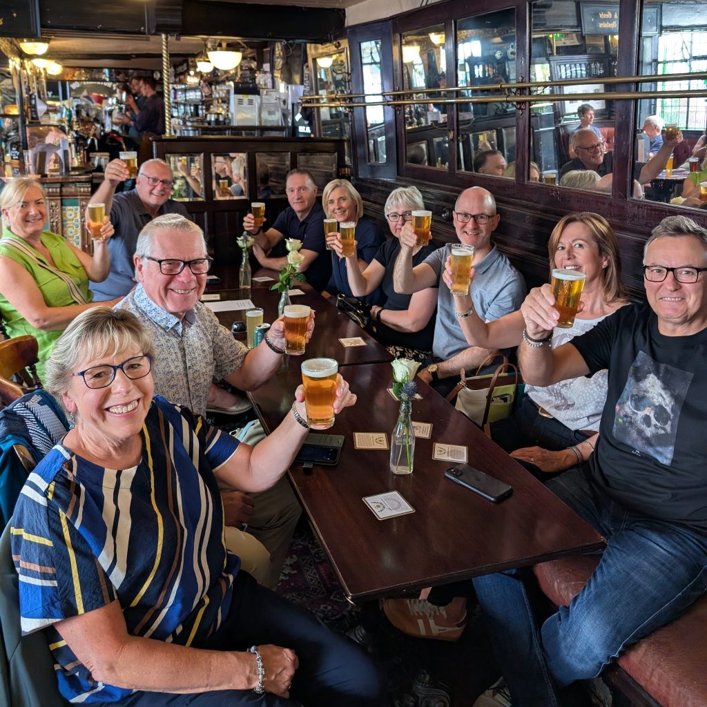 Tour guests with beers toasting the camera in Whitelock's Ale House